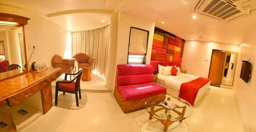 Una habitación de hotel con una cama y una silla roja. en Hotel Amrta, en Nagpur