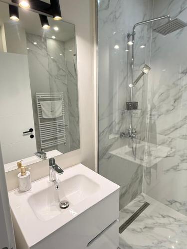 ein weißes Badezimmer mit Waschbecken und Dusche in der Unterkunft COZY Aparthotel - Luxury Studios # Brasov in Braşov