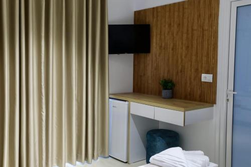 een hotelkamer met een bureau en een gordijn bij Vila Naço Ksamil in Ksamil