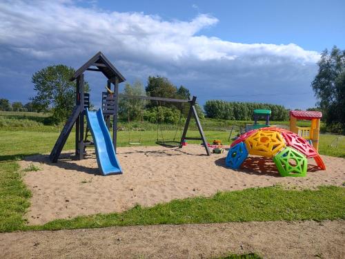 a playground with a slide and a swing set at Chatka in Stegienka