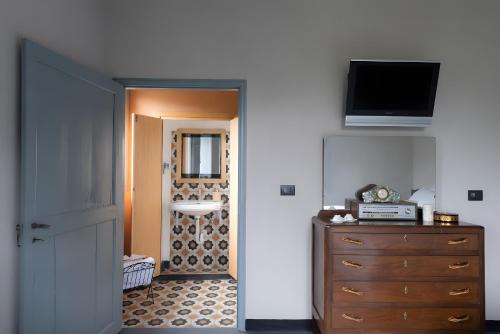 a room with a door and a dresser and a television at Beb La Patataia Home in Bormida