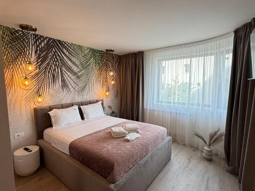 ein Schlafzimmer mit einem großen Bett und einem großen Fenster in der Unterkunft COZY Aparthotel - Luxury Studios # Brasov in Braşov