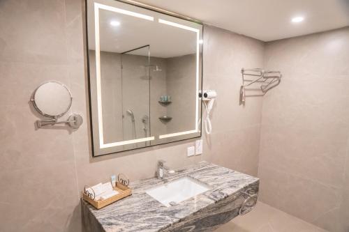 a bathroom with a sink and a mirror at Ramada by Wyndham Murree Lower Topa Resort in Murree