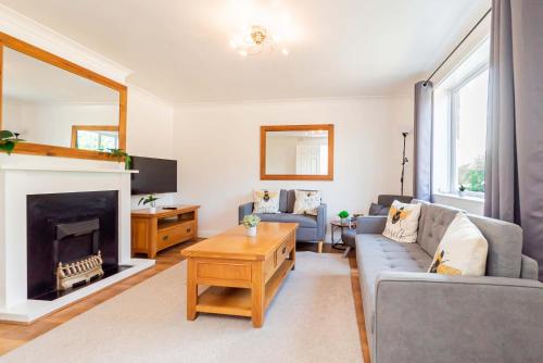a living room with a couch and a fireplace at Beautiful 3 Bedroom Home with Parking & Garden in Colchester