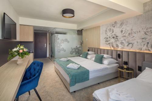 a hotel room with a bed and a desk at Sungarden Wellness Hotel Siófok in Siófok