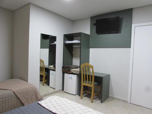 a bedroom with a bed and a desk and a tv at Hotel Paramount- Próximo a "25 de Março Brás Bom Retiro e Distrito do Anhembi Expo Center Norte" in Sao Paulo