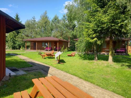 a park with a wooden bench and a cabin at Chatka in Stegienka