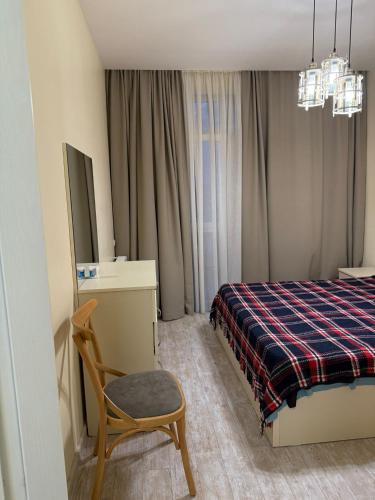 a bedroom with a bed and a chair and a tv at Apartamenti v Batumi in Batumi