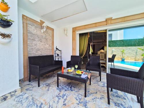 a living room with chairs and a coffee table at L'Orchidée - Suites de Luxe avec Piscine Chauffée et Vue sur le Lac de Tunis in Tunis