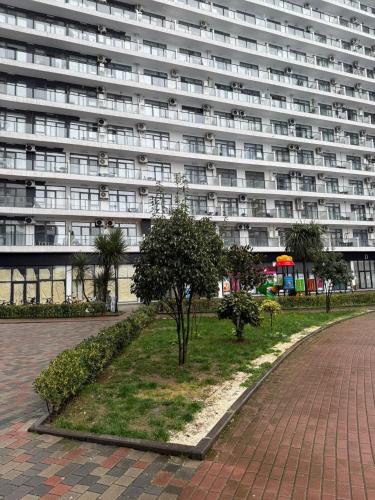 a large building with a park in front of it at Apartamenti v Batumi in Batumi