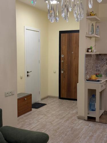 a living room with a door and a chandelier at Apartamenti v Batumi in Batumi