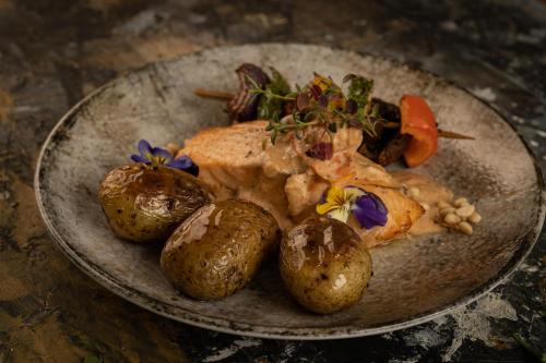 a plate of food with meat and potatoes on a table at Fugl Fønix Hotel in Etnesjøen