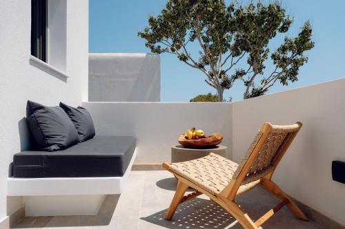 a patio with a chair and a couch at Sohoro Olive in Ios Chora
