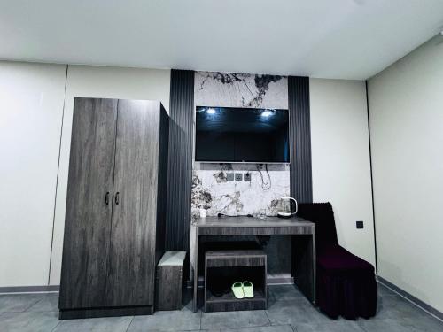 uma sala com uma mesa e uma TV na parede em Lofty Hotel em Ulaanbaatar