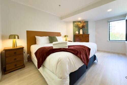 ein Schlafzimmer mit großem Bett und Fenster in der Unterkunft Two bedrooms Condo with Skytower View in Auckland