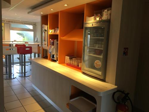 - une cuisine avec un comptoir et un réfrigérateur dans l'établissement Premiere Classe Herblay, à Herblay