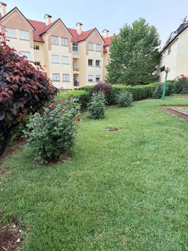 a yard with a building and some bushes and flowers at Dar Dina Havre de paix sous les cèdres d'Ifrane in Ifrane