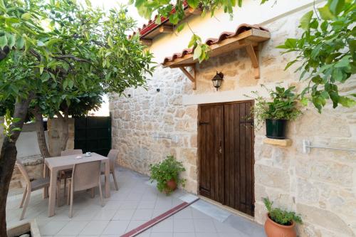 a courtyard with a wooden door and a table and chairs at Petra Vori Studio in Vóroi