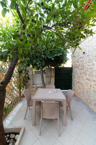 a table and chairs under a tree on a patio at Petra Vori Studio in Vóroi