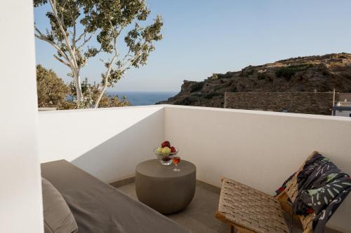 a balcony with a table and a vase of fruit at Sohoro Olive in Ios Chora