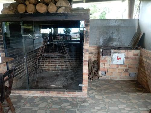 a brick fireplace in a room with logs in it at Cabaña El Retiro en Guaduas in Guaduas