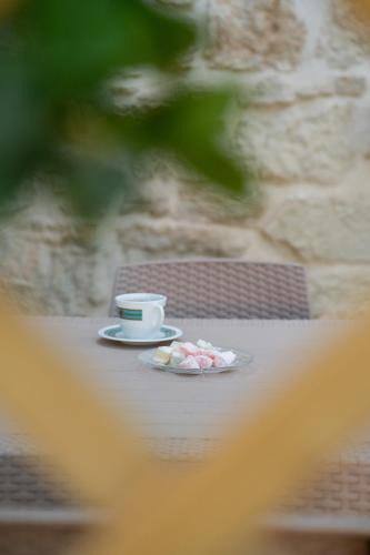 a cup of coffee and a plate on a table at Petra Vori Studio in Vóroi