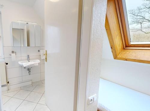 a bathroom with a sink and a window at Reiterpension Marlie in Scharbeutz
