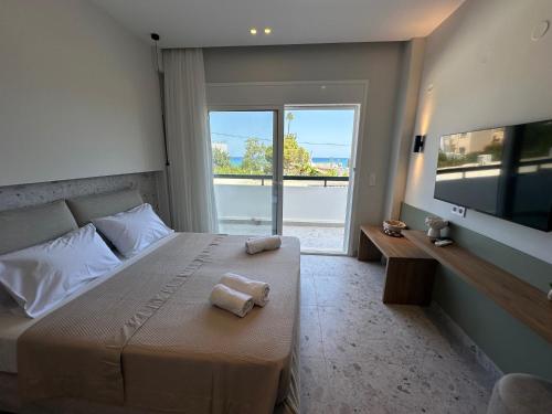 a bedroom with a bed with two towels on it at Liofoto Sea View Apartments in Stalida