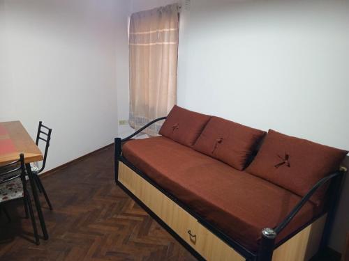 ein Sofa in einem Zimmer mit einem Tisch und einem Fenster in der Unterkunft Leo IV salta 636 4F in San Fernando del Valle de Catamarca