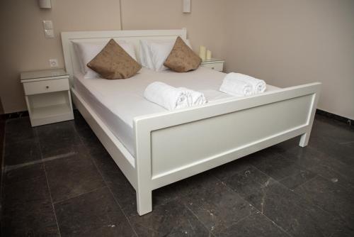 a white bed with two pillows on it at Sofia Luxury Apartments in Lechaio