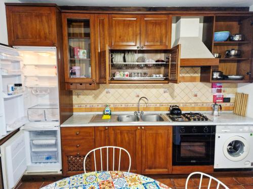 a kitchen with wooden cabinets and a sink and a refrigerator at Appartamento Villa Bianca su "Corso ITALIA" in Sorrento