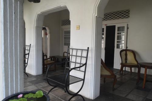 a porch with chairs and tables in a house at Mahagedara in Galle