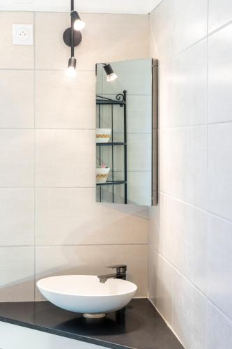 a bathroom with a sink and a mirror at Villa Lazuel, piscine privée chauffée, vue panoramique et jardin clos in Aubenas