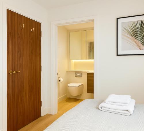 a bedroom with a bed and a toilet and a mirror at Elegant 2 Bed Flat with Balcony in Finchley in Hendon
