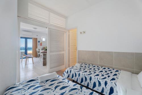a bedroom with two beds and a view of the ocean at Apartamentos Playa Azul - 5 in Vallehermoso