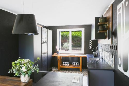a kitchen with black walls and a table and a window at Villa Saint-Martin in Jullouville-les-Pins