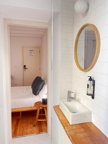 a bathroom with a sink and a bed in a room at Loureiro 59 in Coimbra