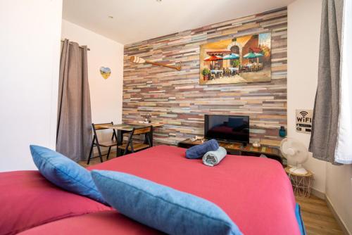 una camera con letto rosso e cuscini blu di L'Orphie - 50m plage - confort - Baignoire a Berck-sur-Mer