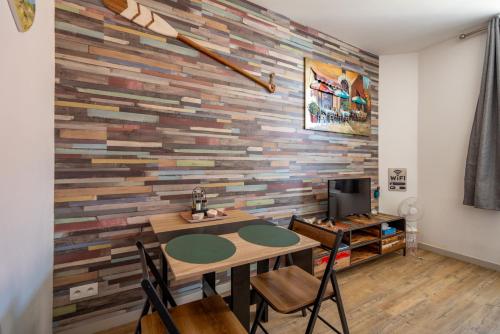 une salle à manger avec un mur en bois dans l'établissement L'Orphie - 50m plage - confort - Baignoire, à Berck-sur-Mer