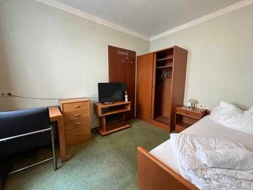 a room with two beds and a desk with a television at Aparthotel Mariazellerhof in Sankt Pölten