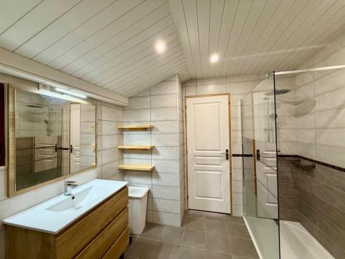 Un baño con lavabo, ducha e inodoro. en Chalet des Boutons d'Or, peaceful with terrace, en Gerbépal