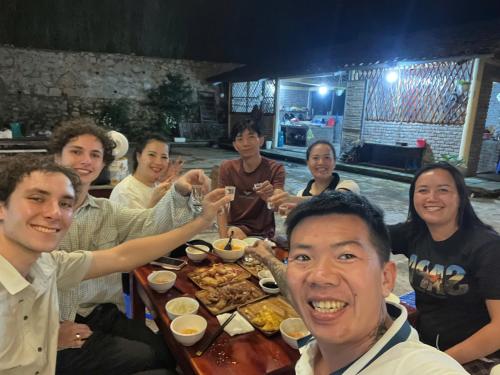 a group of people sitting around a table eating food at Mùa Pửi Lô lô homestay in Mèo Vạc