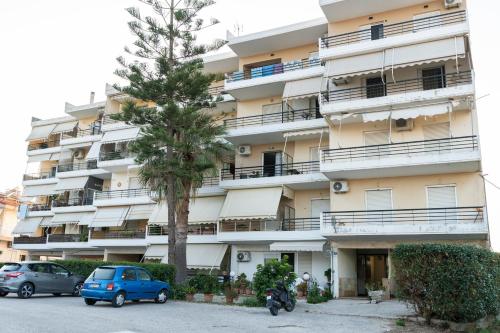 a large apartment building with cars parked in front of it at matarooms in Preveza