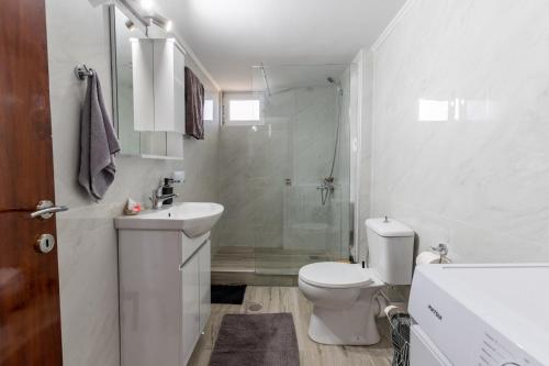 a white bathroom with a toilet and a shower at matarooms in Preveza