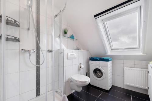 a bathroom with a toilet and a washing machine at 3 Raum Ferienwohnung Im 1 Og in Cuxhaven