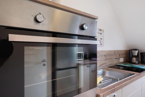 a kitchen with a stainless steel refrigerator and a sink at 3 Raum Ferienwohnung Im 1 Og in Cuxhaven