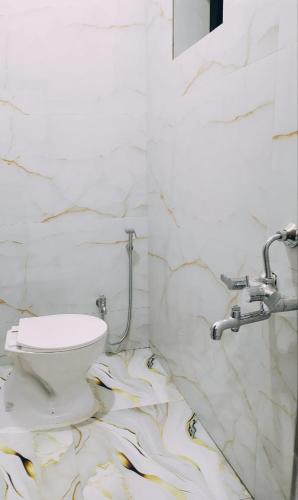 a bathroom with a white toilet and a sink at Anand Nivas Homestay 10 Mins from Mandir in Deoghar
