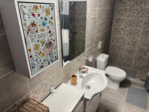 a bathroom with a sink and a toilet and a mirror at Sofia Luxury Apartments in Lechaio