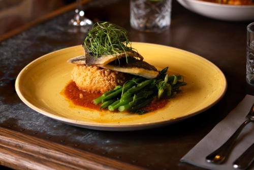 a plate of food with fish and vegetables on a table at The Gannet Inn in St Ives