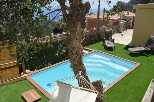 een boom met een hangmat naast een zwembad bij Anglada, Villa with a private pool and jacuzzi in Lloret de Mar